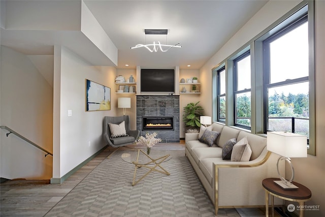 living room with a tiled fireplace and light hardwood / wood-style floors