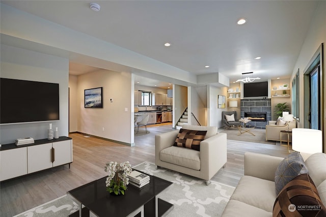 living room featuring a tile fireplace and light hardwood / wood-style flooring