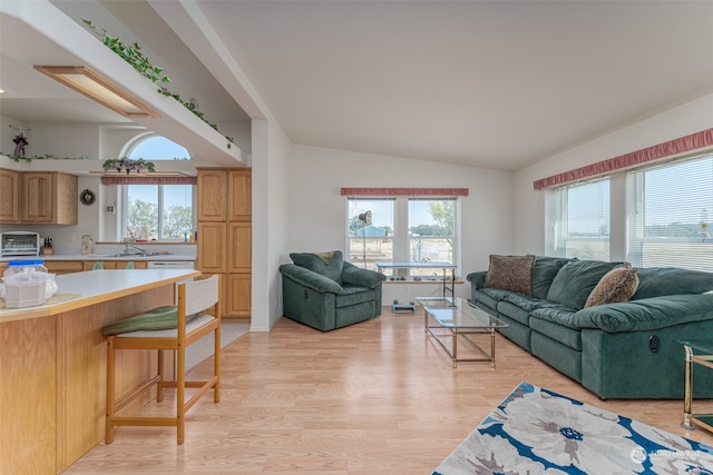 living room with vaulted ceiling and light hardwood / wood-style floors