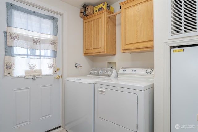 washroom with washing machine and clothes dryer and cabinets