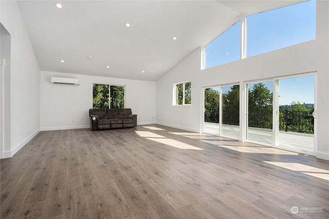 unfurnished living room featuring light hardwood / wood-style floors, a wall mounted air conditioner, and a wealth of natural light