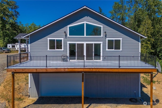 back of house with a garage and a wooden deck