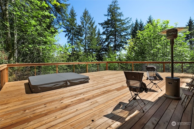 deck featuring a covered hot tub