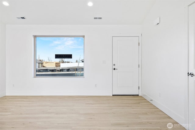 unfurnished room with baseboards, visible vents, and light wood finished floors