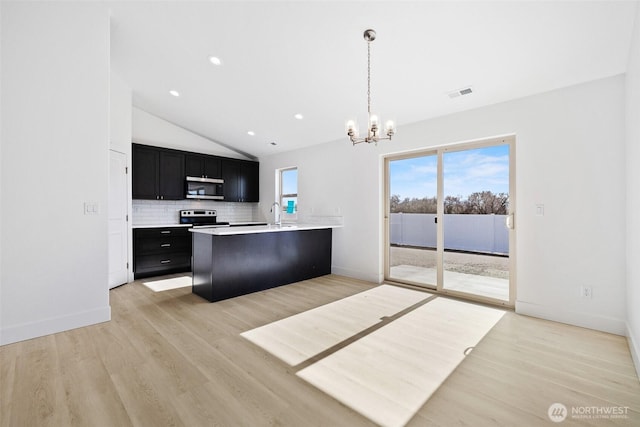 kitchen with visible vents, appliances with stainless steel finishes, dark cabinets, light countertops, and backsplash