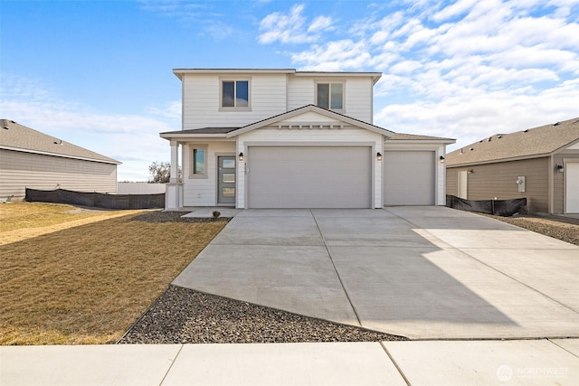 traditional-style home featuring a front yard, concrete driveway, and an attached garage