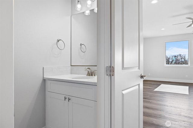 bathroom featuring recessed lighting, ceiling fan, vanity, wood finished floors, and baseboards