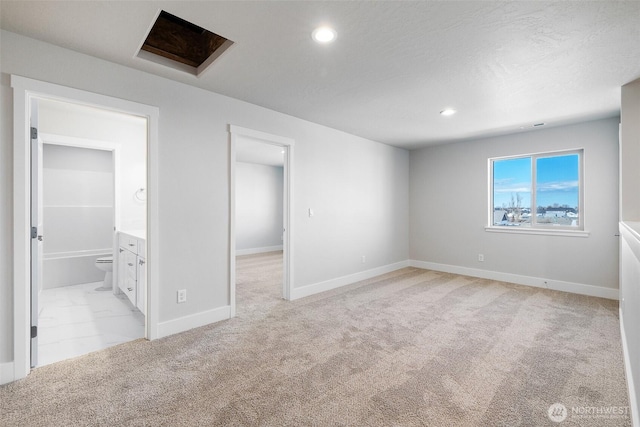 interior space with light carpet, attic access, baseboards, and recessed lighting