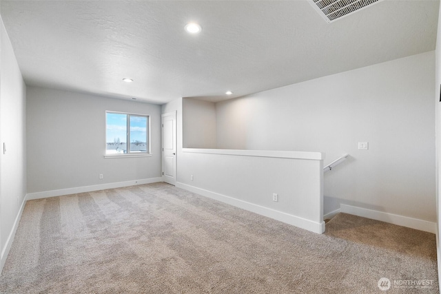 empty room featuring carpet floors, baseboards, and recessed lighting