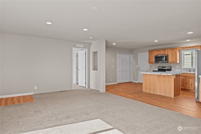 kitchen with light hardwood / wood-style floors, appliances with stainless steel finishes, and a kitchen island