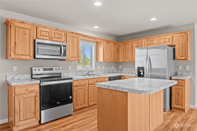 kitchen with light hardwood / wood-style floors, sink, a kitchen island, and stainless steel appliances