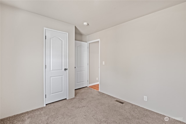 unfurnished bedroom featuring light carpet