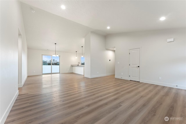 unfurnished living room with high vaulted ceiling and wood-type flooring