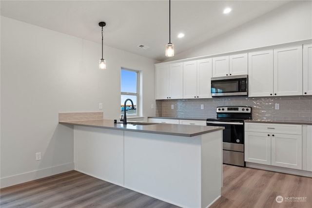 kitchen with kitchen peninsula, white cabinetry, sink, and appliances with stainless steel finishes