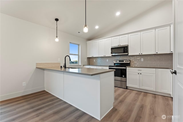 kitchen featuring white cabinets, appliances with stainless steel finishes, and kitchen peninsula