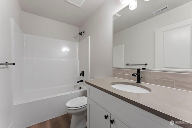 full bathroom with tasteful backsplash, vanity, shower / bathing tub combination, hardwood / wood-style floors, and toilet