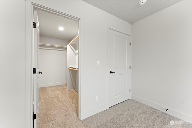 spacious closet with light colored carpet