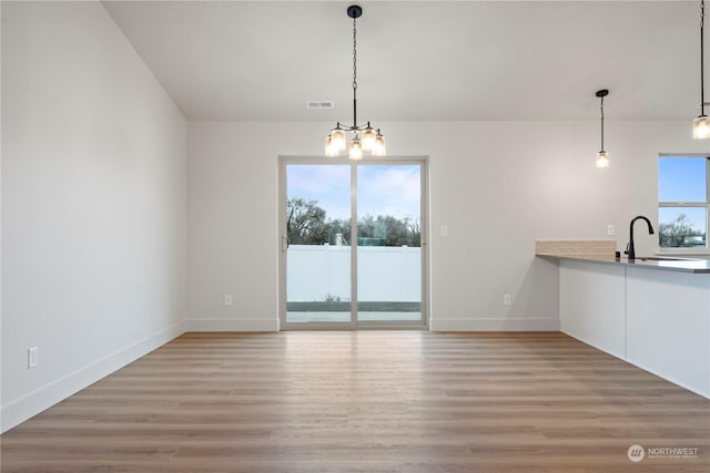 interior space with a chandelier, hardwood / wood-style floors, and sink