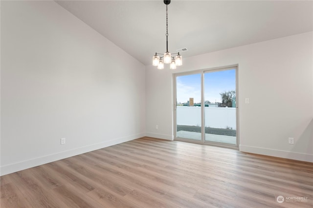 spare room with light hardwood / wood-style floors, lofted ceiling, and a chandelier