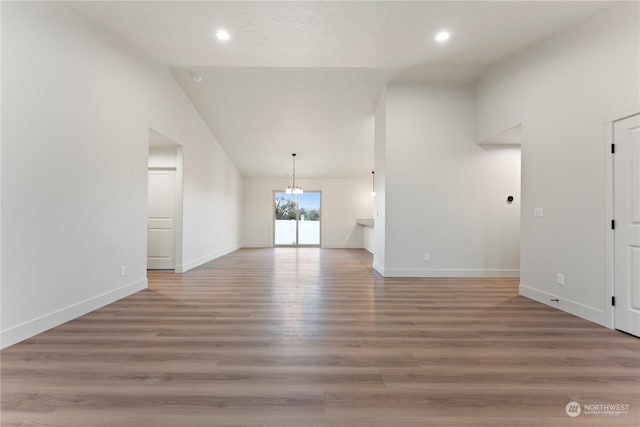 unfurnished living room with hardwood / wood-style floors and high vaulted ceiling