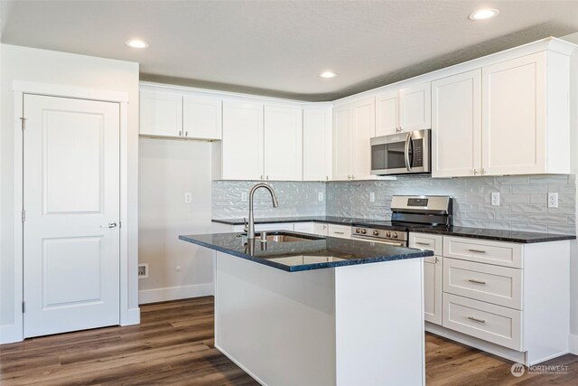 kitchen featuring stainless steel appliances, a kitchen island with sink, sink, and white cabinets