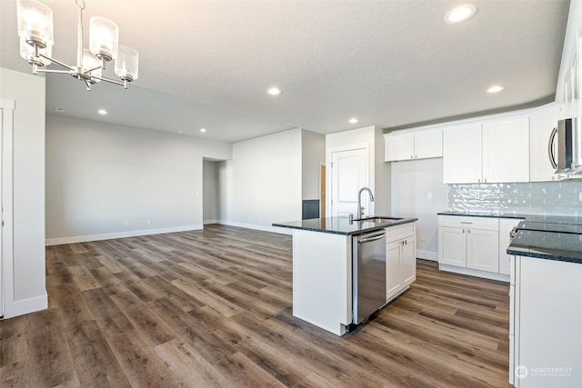 kitchen with white cabinetry, sink, hanging light fixtures, a kitchen island with sink, and stainless steel appliances