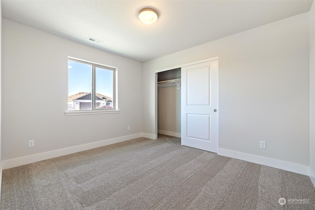 unfurnished bedroom featuring carpet floors and a closet