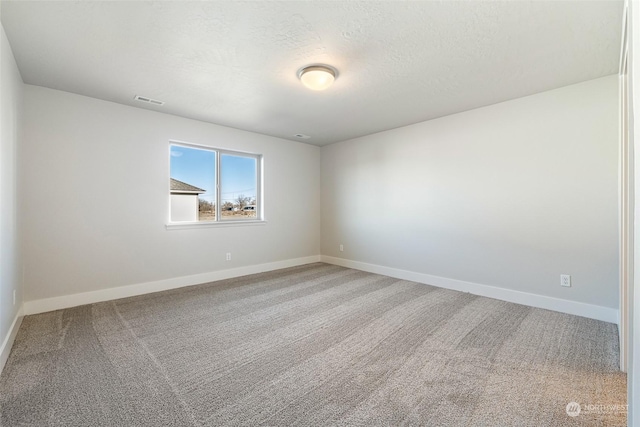 carpeted spare room featuring a textured ceiling