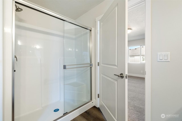 bathroom with an enclosed shower and a textured ceiling