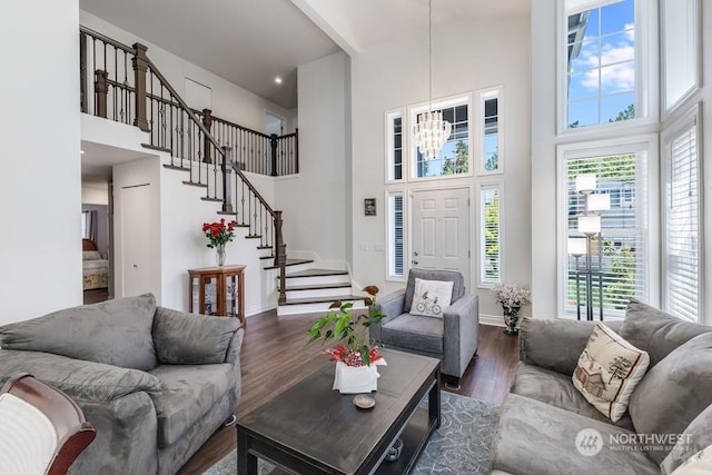 living room featuring dark hardwood / wood-style floors, a high ceiling, and a notable chandelier