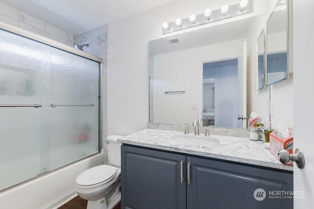 full bathroom with vanity, toilet, and enclosed tub / shower combo