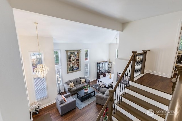 stairway with hardwood / wood-style flooring and an inviting chandelier