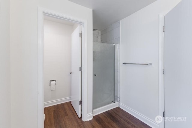 bathroom with a shower with shower door and wood-type flooring