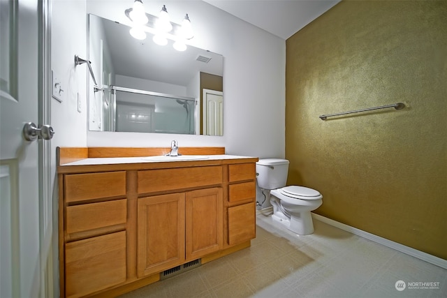 bathroom with vanity, toilet, and a shower with shower door