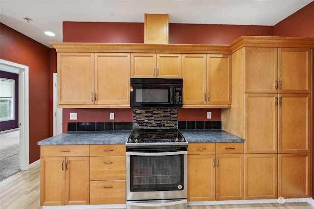 kitchen featuring light wood-type flooring, stainless steel stove, and tasteful backsplash