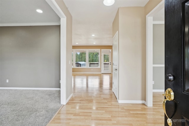 hall with light hardwood / wood-style flooring and ornamental molding