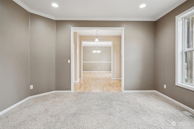 empty room with crown molding, light carpet, and a notable chandelier