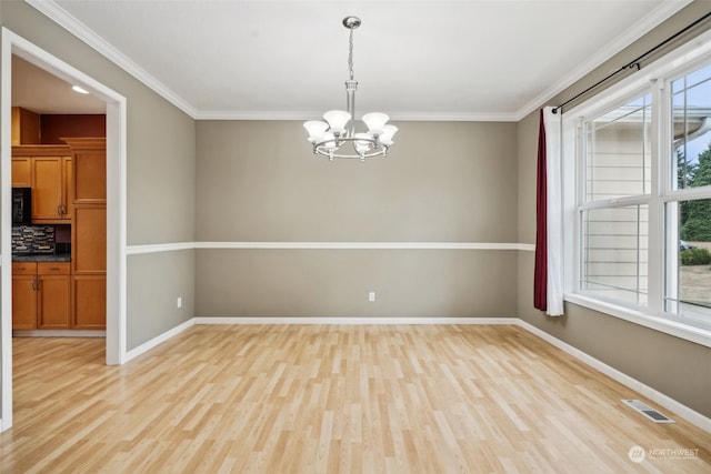 unfurnished room featuring an inviting chandelier, light wood-type flooring, and ornamental molding