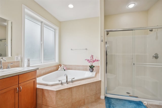 bathroom with tile patterned flooring, vanity, and separate shower and tub