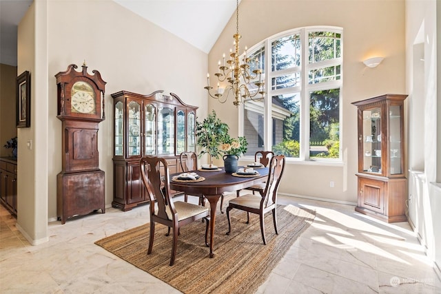 dining room with high vaulted ceiling, a chandelier, marble finish floor, and baseboards