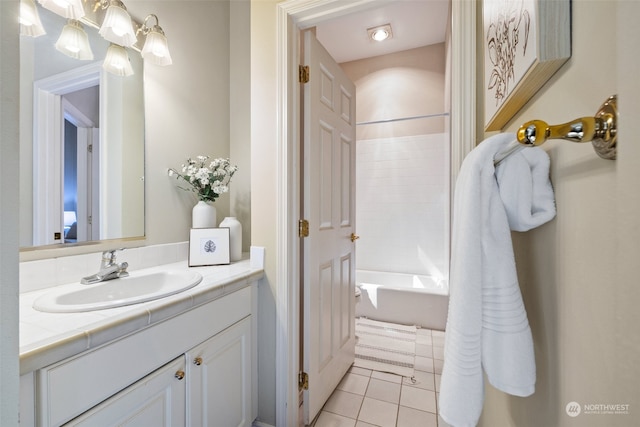 bathroom with tile patterned floors, vanity, and tiled shower / bath