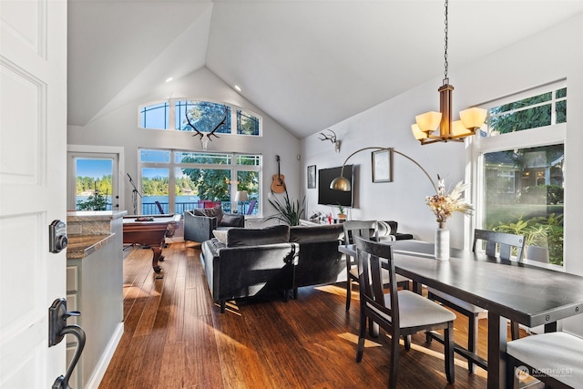 dining area with dark hardwood / wood-style flooring, an inviting chandelier, a wealth of natural light, and high vaulted ceiling