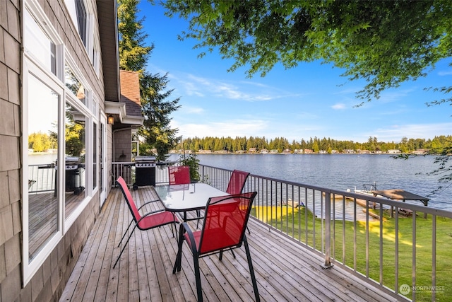 deck featuring area for grilling, a yard, and a water view