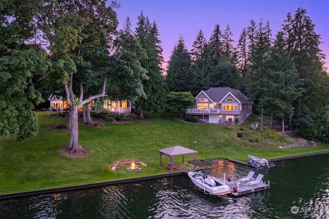 yard at dusk with a water view and a dock