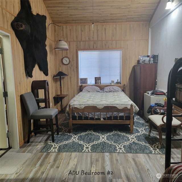 bedroom with hardwood / wood-style flooring, wood ceiling, and wooden walls