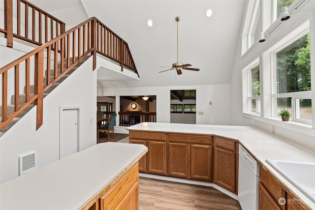 kitchen with high vaulted ceiling, white dishwasher, sink, ceiling fan, and light hardwood / wood-style floors