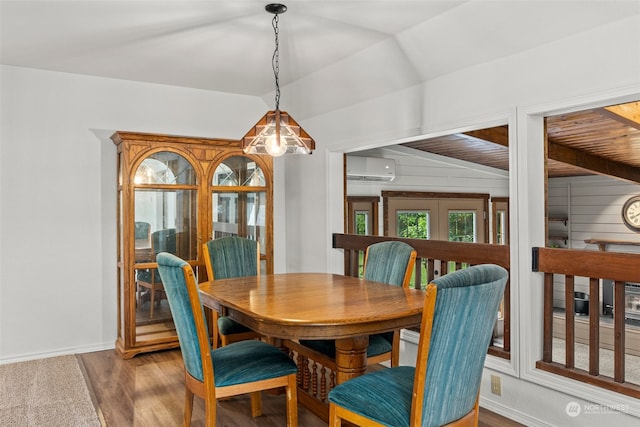 dining area featuring wood-type flooring, french doors, a wall unit AC, and vaulted ceiling