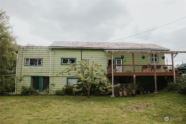 back of property with a lawn and a wooden deck