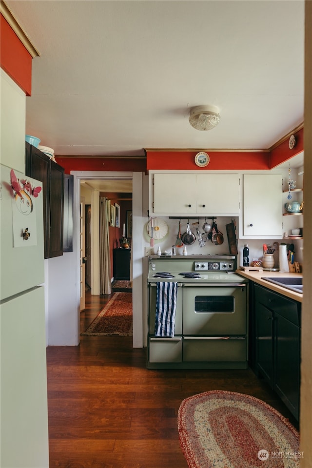 kitchen featuring sink, white cabinetry, dark hardwood / wood-style flooring, and white appliances