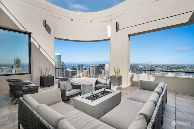 view of patio / terrace featuring a balcony, an outdoor living space with a fire pit, and a water view